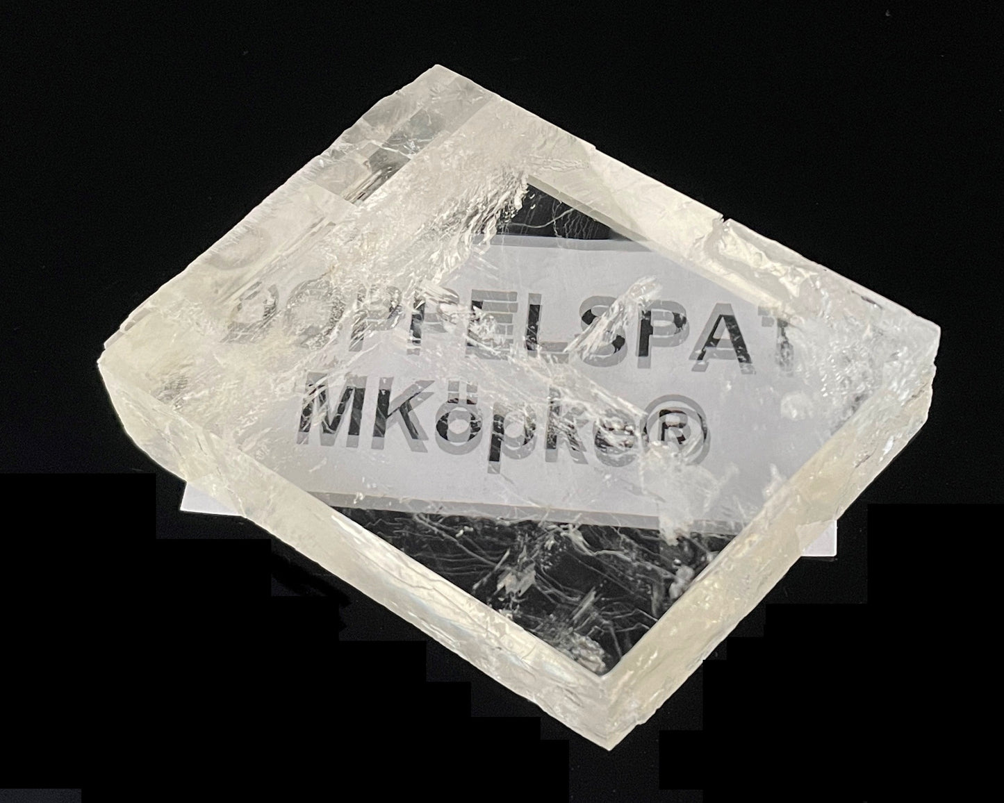 Ansicht von oben: Einzelner Calcit-Kristall (Doppelspat) mit sichtbarer doppelter Schrift