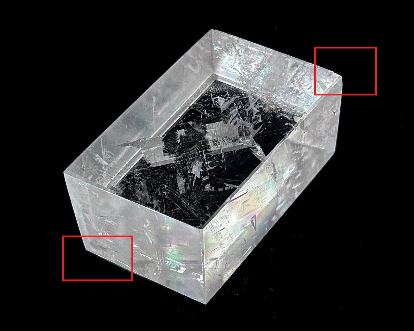 Einzelner polierter Calcit Kristall mit Bestoßung rot eingezeichnet auf schwarzem Hintergrund