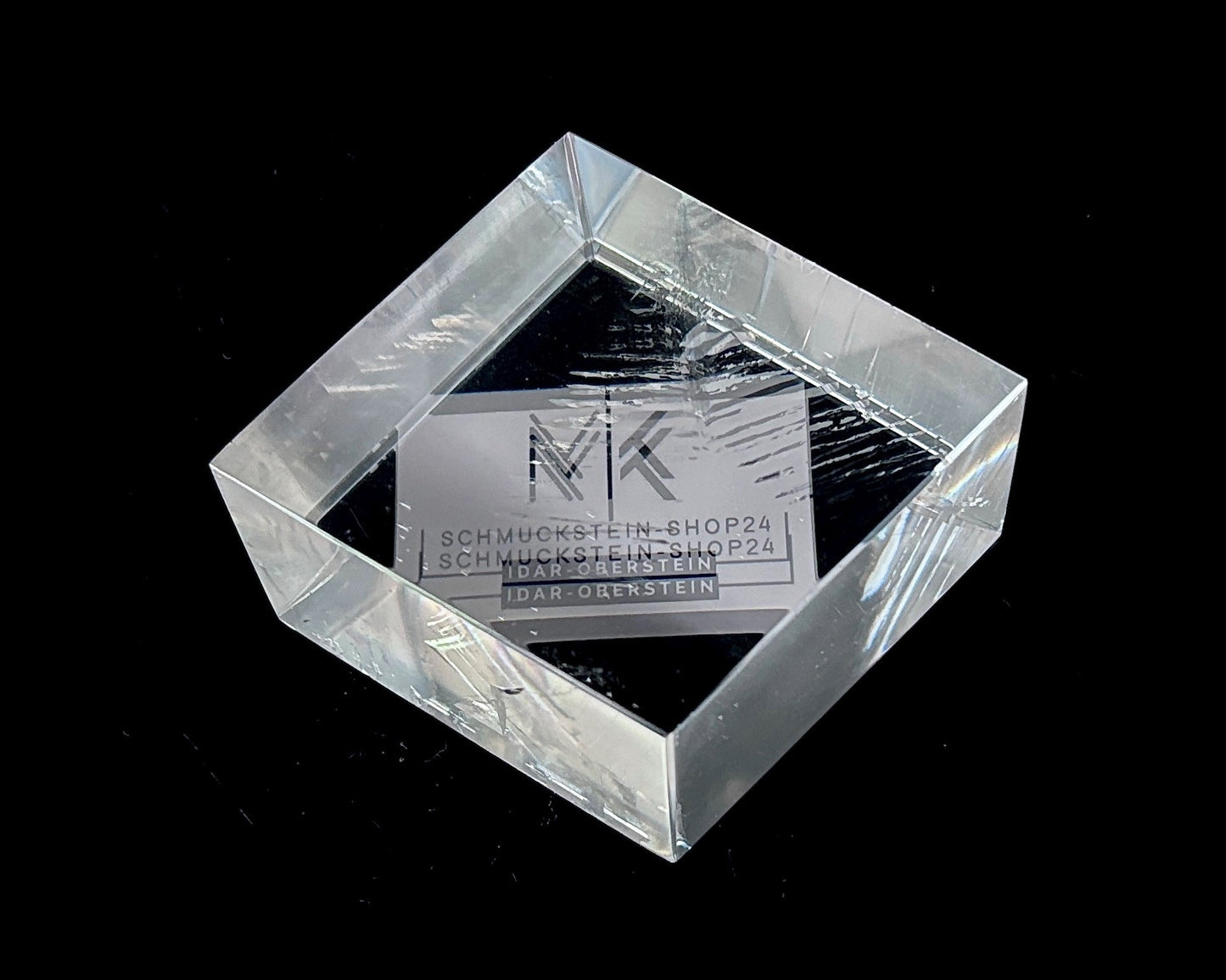 Einzelner polierter Calcit Kristall mit Doppelbrechung auf schwarzem Hintergrund