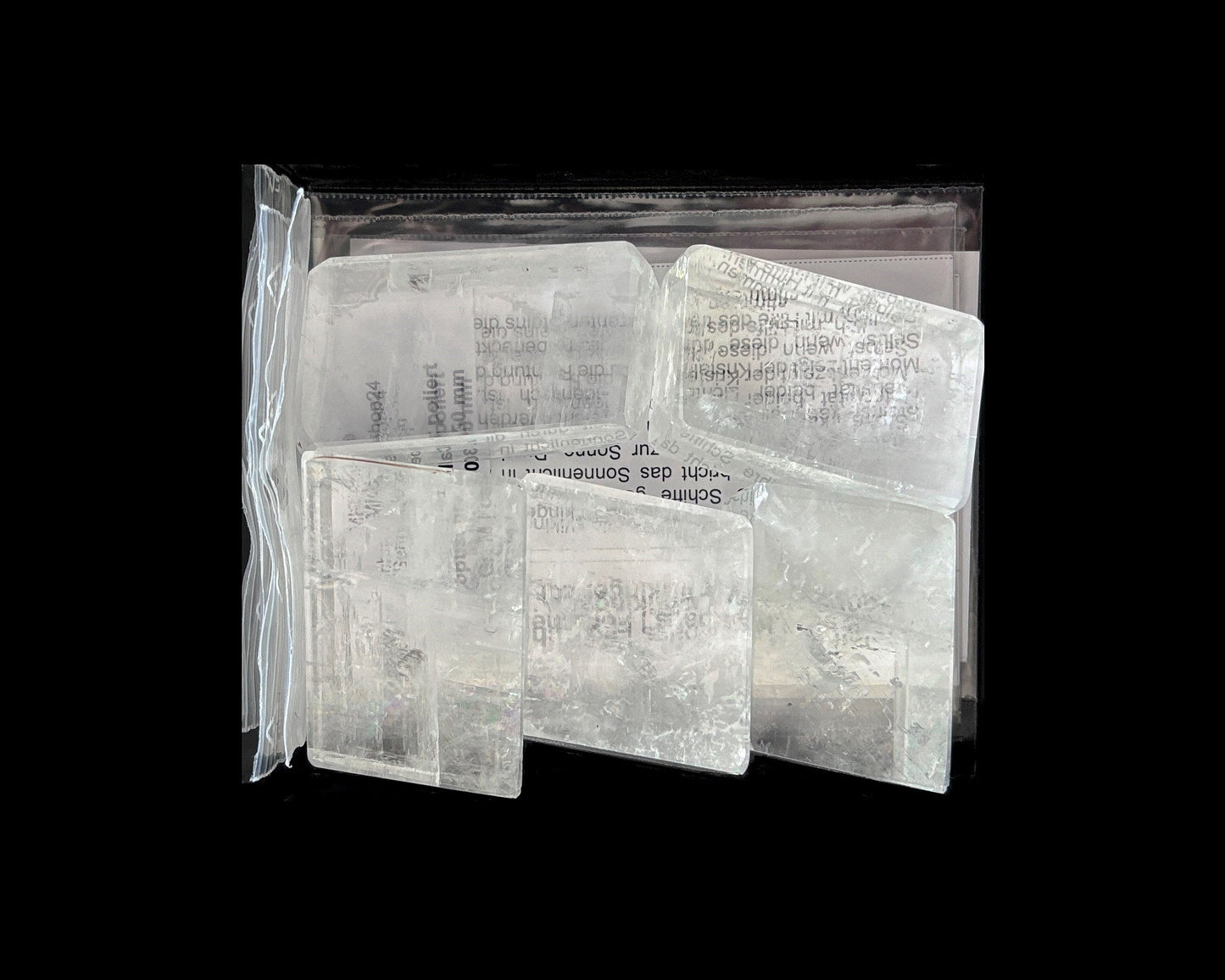 Ansicht von oben: Calcite Kristalle (Doppelspat) mit sichtbarer doppelter Schrift im Größenvergleich