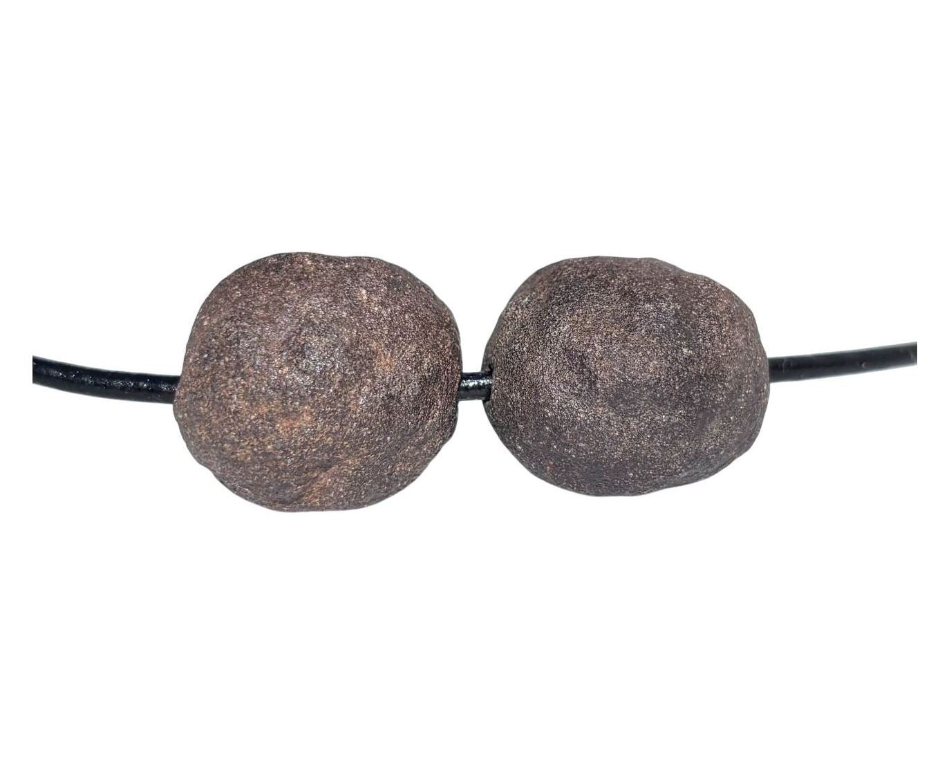 Moqui Marbles Paar mit Lederband auf weißem Hintergrund