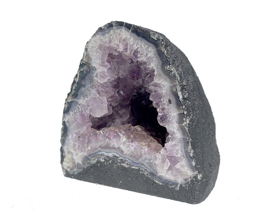 Seitenansicht: einzelne Amethyst Druse mit violetten Kristallen auf weißem Hintergrund