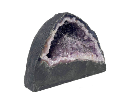 Seitenansicht: einzelne Amethyst Druse mit violetten Kristallen auf weißem Hintergrund