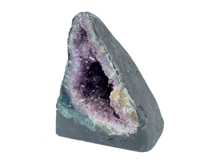 Seitenansicht: einzelne Amethyst Druse mit violetten Kristallen auf weißem Hintergrund