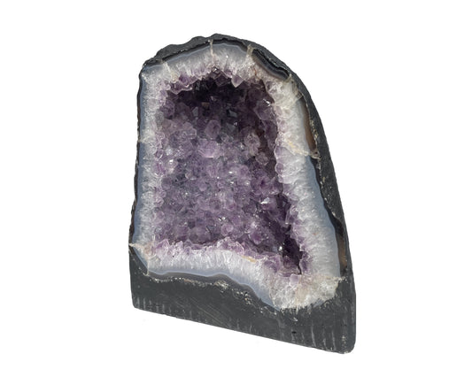 Seitenansicht: einzelne Amethyst Druse mit violetten Kristallen auf weißem Hintergrund