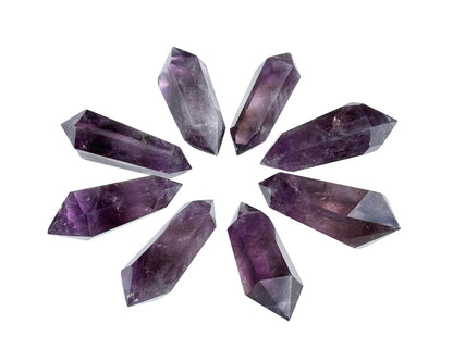 Vielzahl an dunkel violetten Amethyst Doppelenern auf weißem Hintergrund