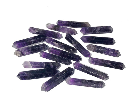 Vielzahl an dunkel violetten Amethyst Doppelenern auf weißem Hintergrund