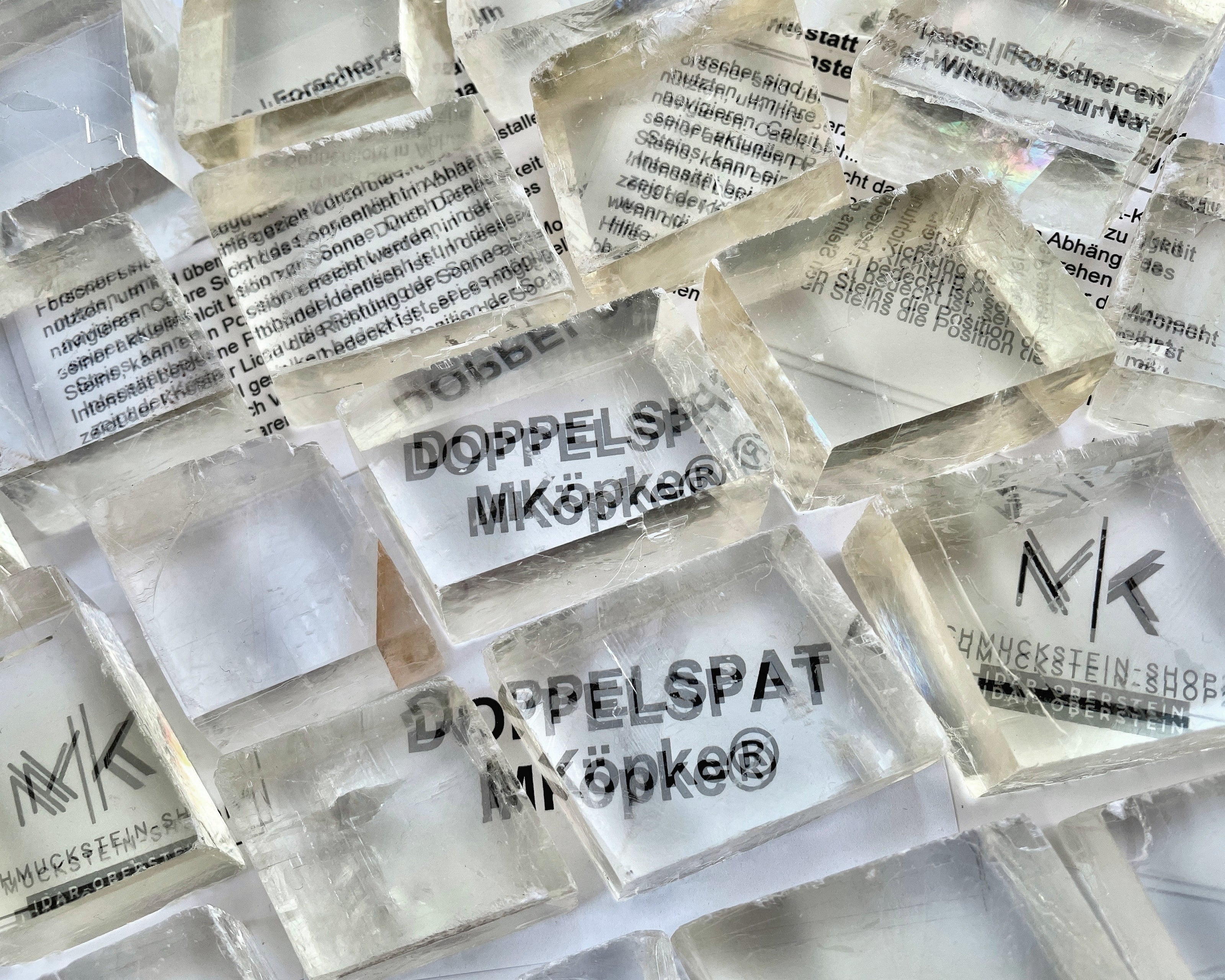 Ansicht von oben: Viele Calcit Kristalle (Doppelspat), die Schrift erscheint doppelt und verschoben auf dem Papier