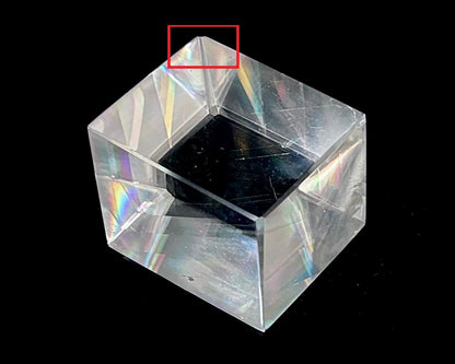 Einzelner polierter Calcit Kristall mit Bestoßung rot eingezeichnet auf schwarzem Hintergrund