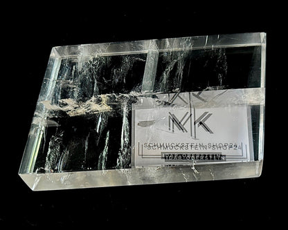 Einzelner polierter Calcit Kristall mit Doppelbrechung auf schwarzem Hintergrund