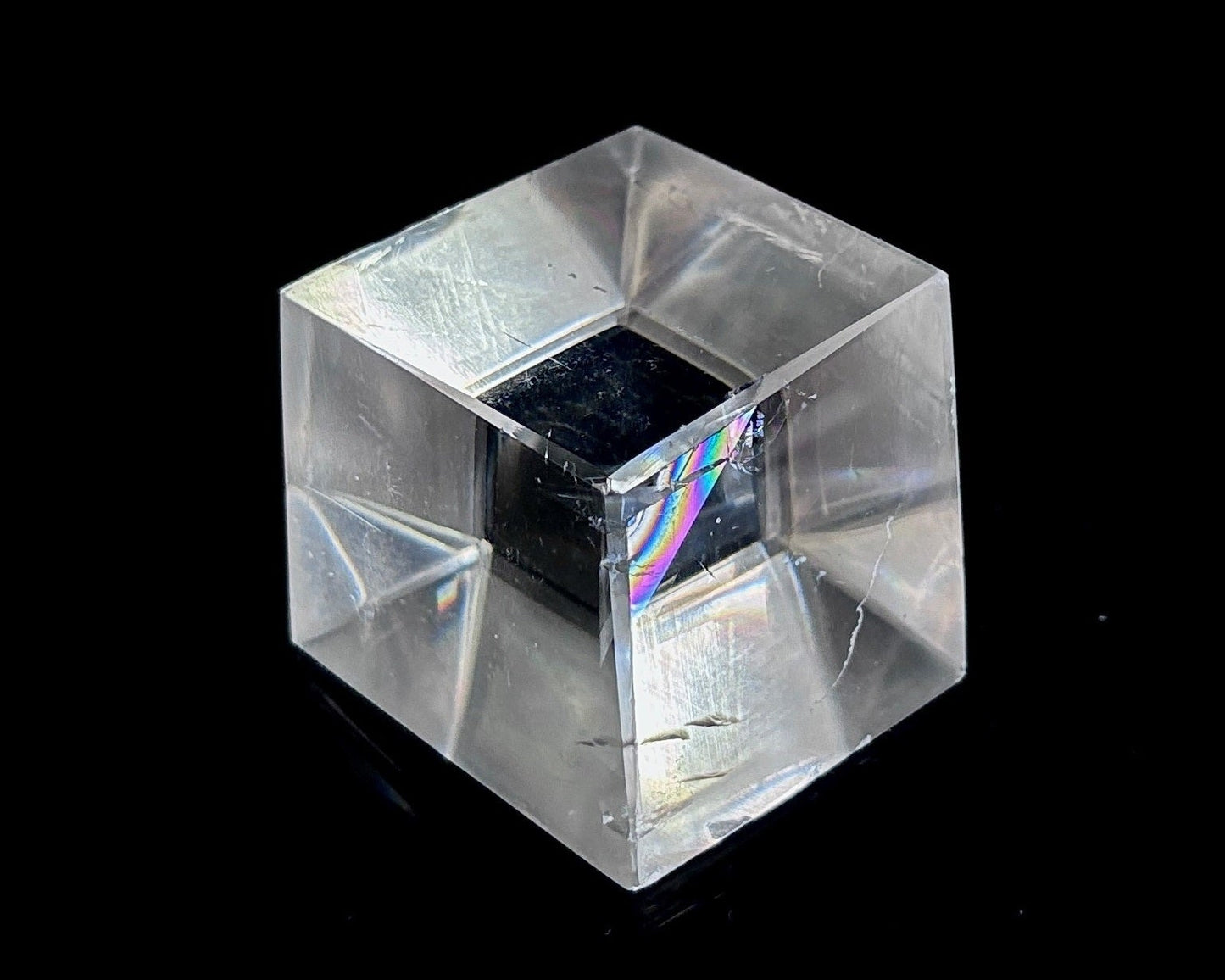 Einzelner polierter Calcit Kristall mit Doppelbrechung auf schwarzem Hintergrund