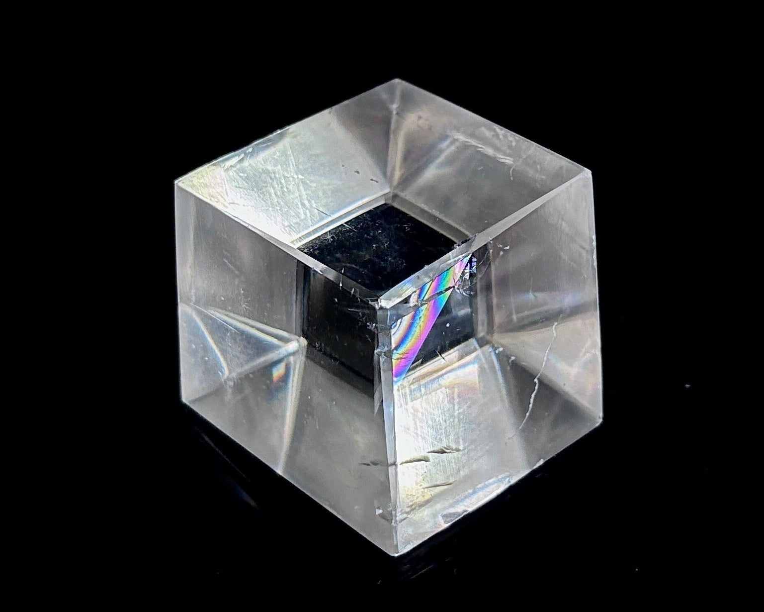 Einzelner polierter Calcit Kristall mit Doppelbrechung auf schwarzem Hintergrund