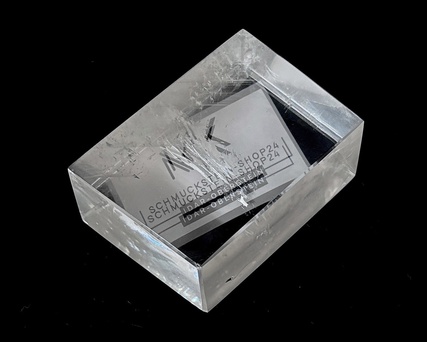 Einzelner polierter Calcit Kristall mit Doppelbrechung auf schwarzem Hintergrund