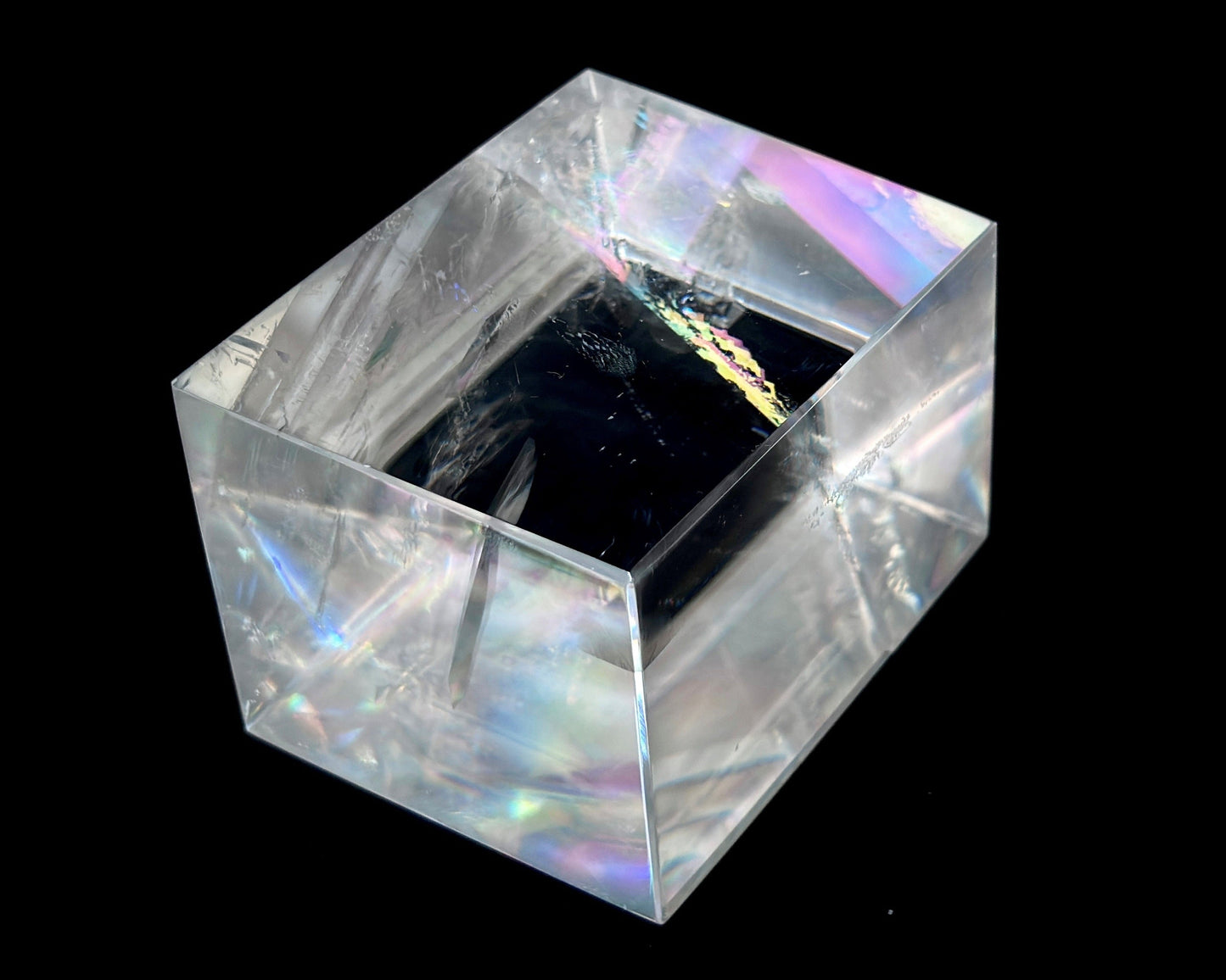 Einzelner polierter Calcit Kristall mit Lichtbrechung auf schwarzem Hintergrund