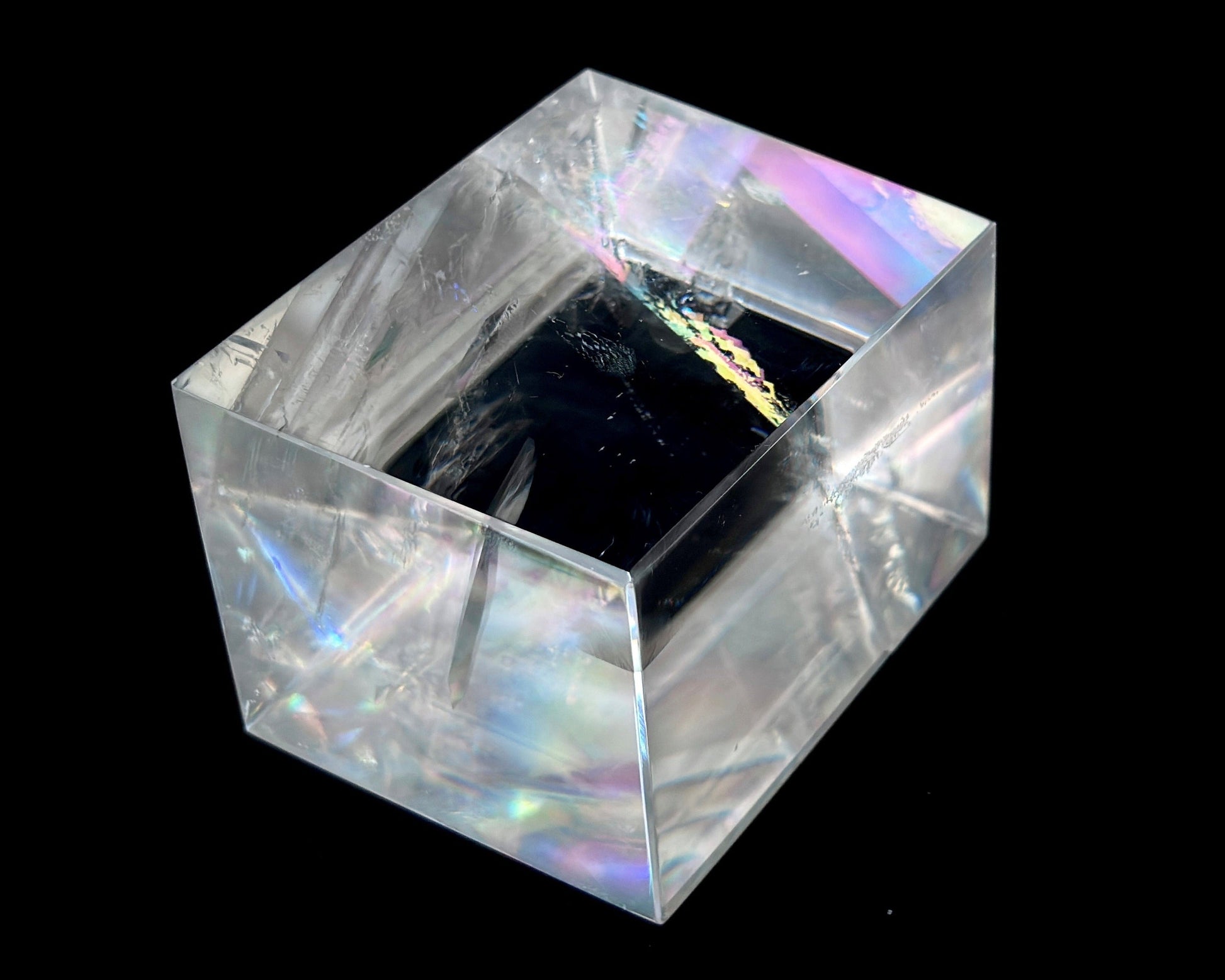 Einzelner polierter Calcit Kristall mit Lichtbrechung auf schwarzem Hintergrund