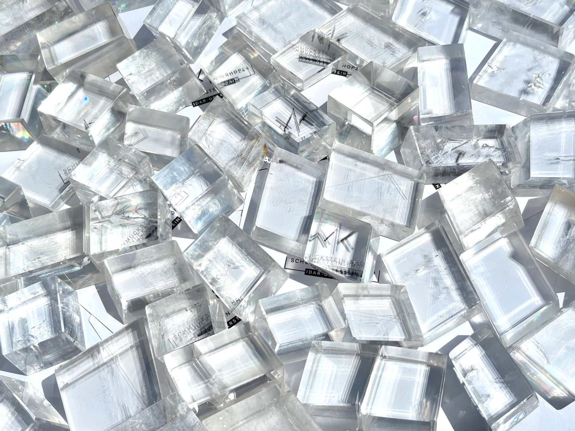 Ansicht von oben: Vielzahl an Calcit Kristallen (Doppelspat) mit sichtbarer doppelter Schrift im Größenvergleich