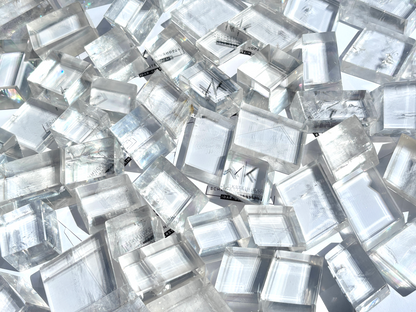 Ansicht von oben: Vielzahl an Calcit Kristallen (Doppelspat) mit sichtbarer doppelter Schrift im Größenvergleich