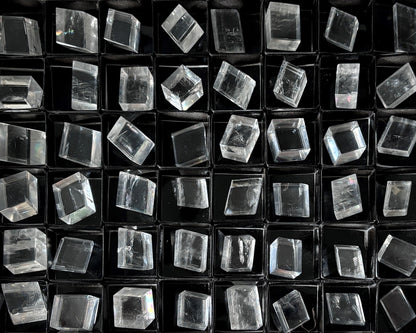 Sammlung polierter kristallklarer Calcit Kristalle (Doppelspat) auf schwarzem Hintergrund