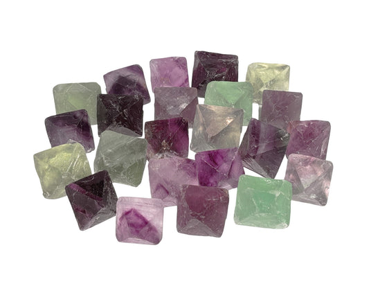 Sammlung von Fluorit Kristallen in Oktaederform in violett und grün auf weißem Hintergrund