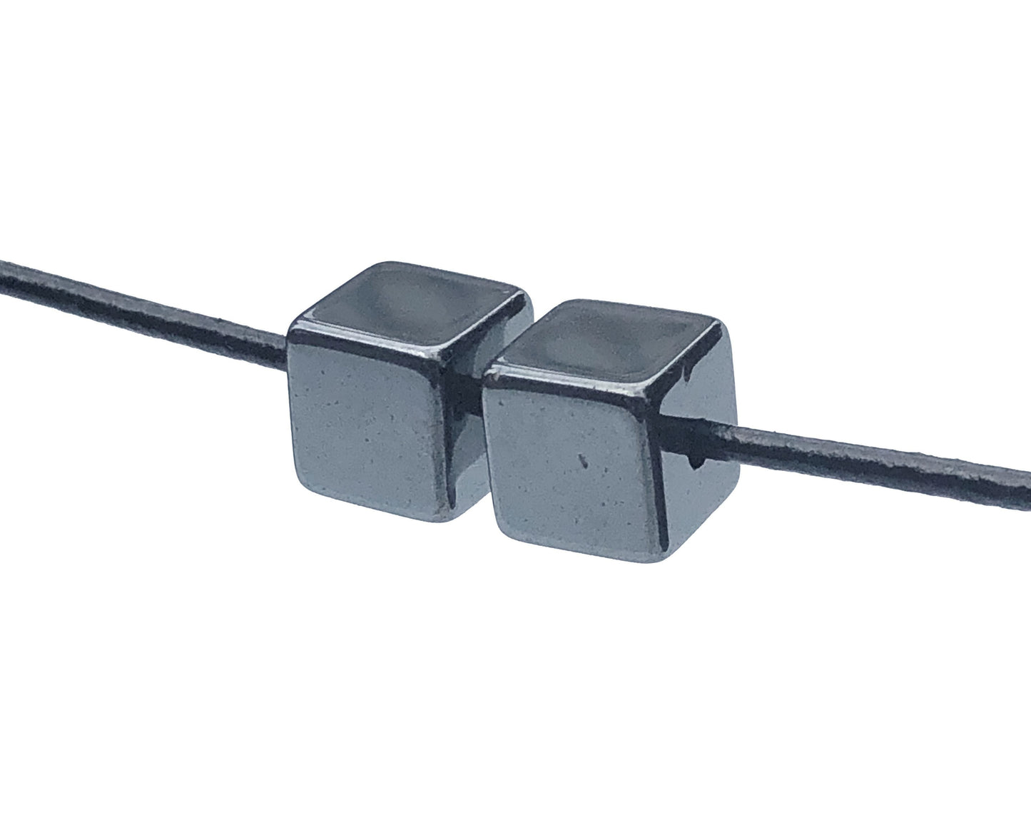 2er-Set Hämatit Würfel Anhänger mit Lederband auf weißem Hintergrund
