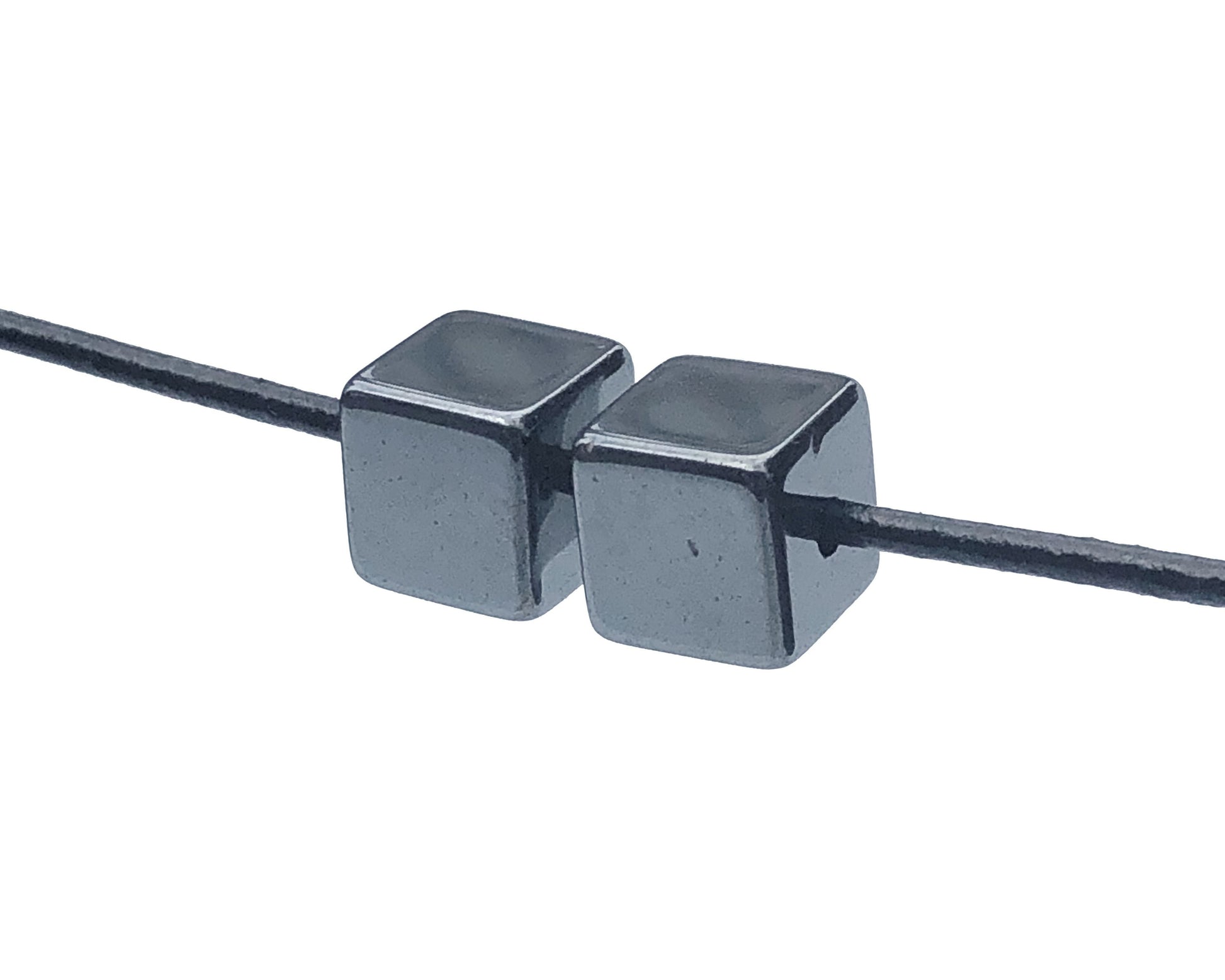2er-Set Hämatit Würfel Anhänger mit Lederband auf weißem Hintergrund