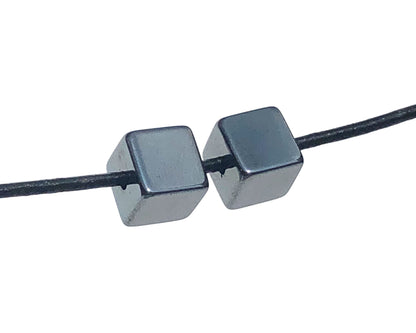 2er-Set Hämatit Anhänger in Würfelform mit Lederband auf weißem Hintergrund