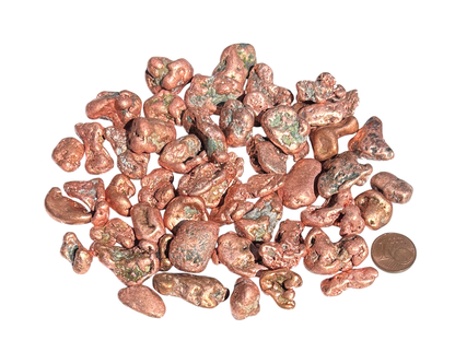 Vielzahl an Kupfer Nuggets auf weißem Hintergrund im Größenvergleich mit einem Pfennig