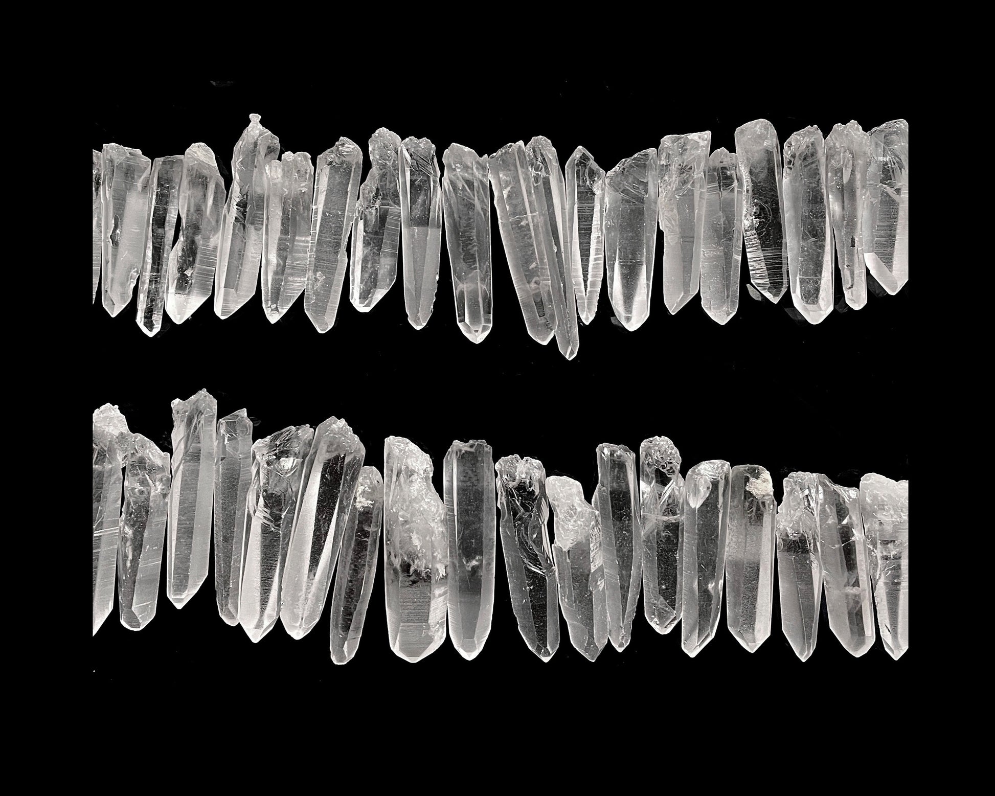 Ansicht von oben: Sammlung von Laserkristallen auf schwarzem Hintergrund