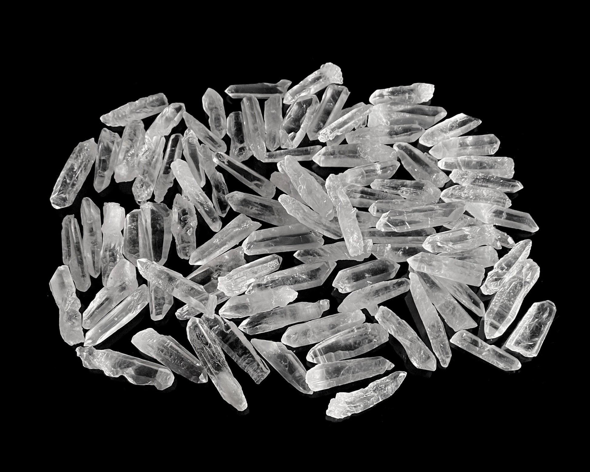 kleine Bergkristall Laserquarze in verschiedenen Formen auf schwarzem Hintergrund