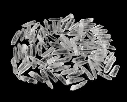 kleine Bergkristall Laserquarze in verschiedenen Formen auf schwarzem Hintergrund