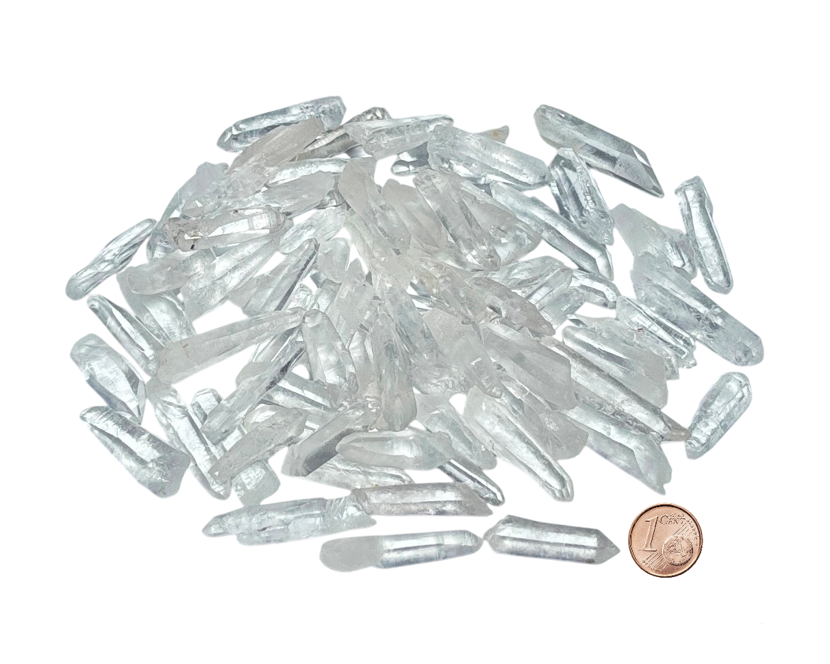 kleine Bergkristall Laserquarze in verschiedenen Formen  auf weißem Hintergrund im Größenvergleich mit einem Pfennig