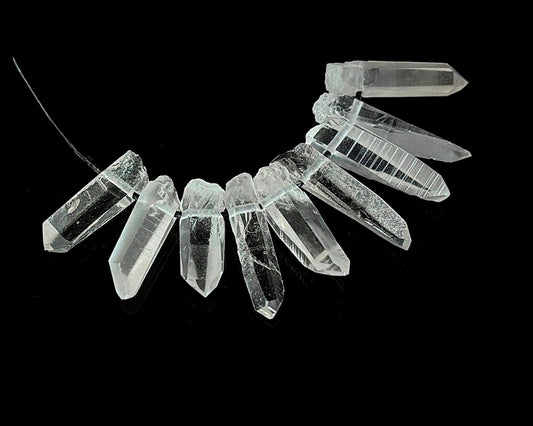 Vorderansicht: natürliche Bergkristall Laserquarz Anhänger mit Band auf schwarzem Hintergrund