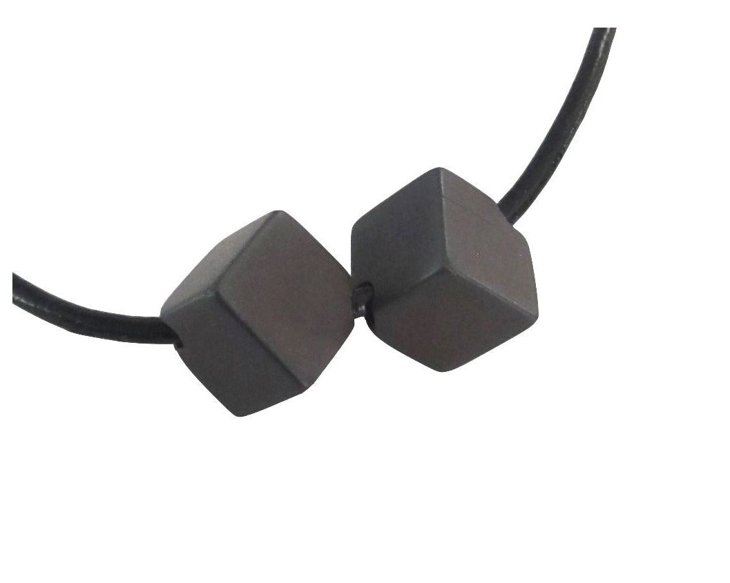 2er-Set Magnetit Würfel Anhänger mit Lederband auf weißem Hintergrund