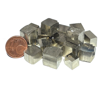 Vielzahl an natürlichen Pyrit Kristalle im Größenvergleich mit einem Pfennig