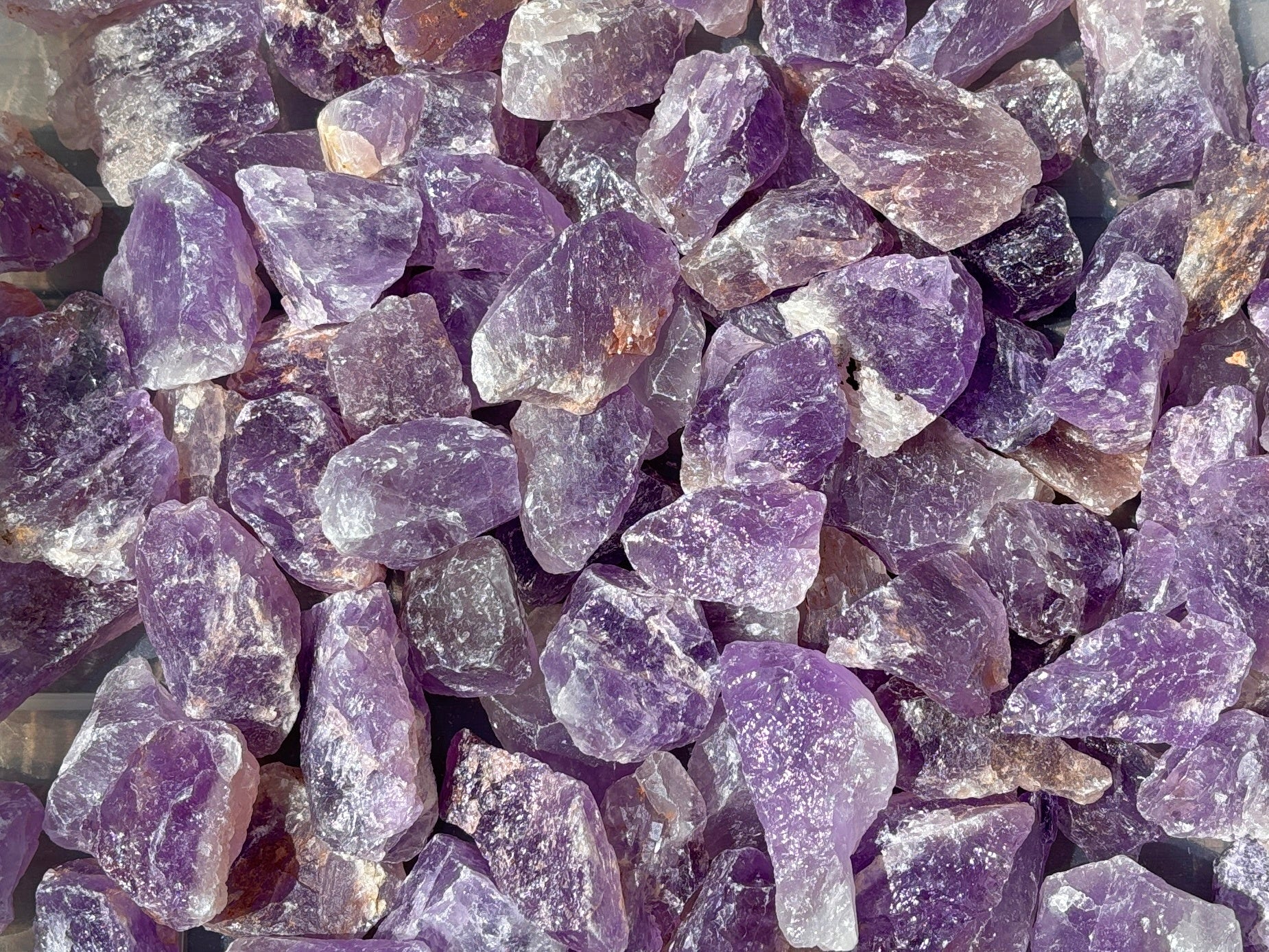 Ansicht von oben: violette Amethyst Rohsteine auf weißem Hintergrund