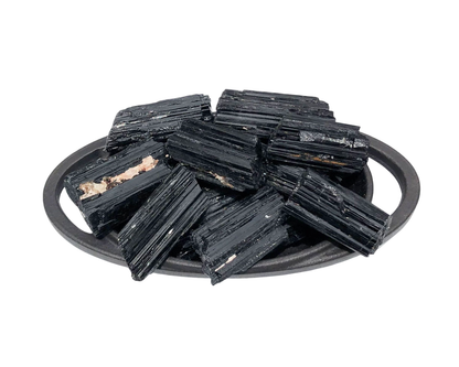 Ansammlung natürlicher Turmalin Schörl Kristalle in einer Schale auf weißem Hintergrund