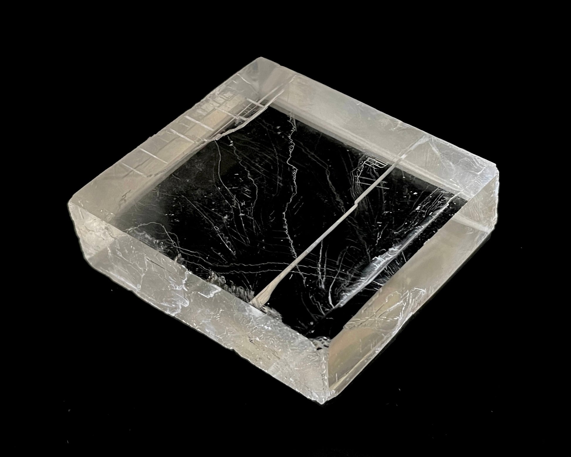 optischer Calcit mit Lichtbrechung auf schwarzem Hintergrund