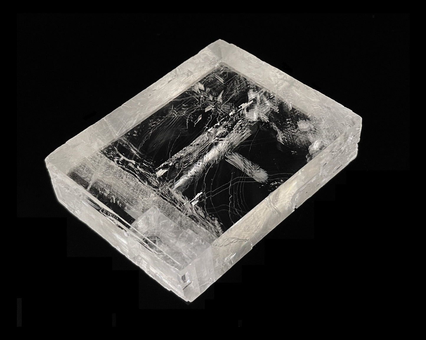 optischer Calcit mit Doppelbrechung auf schwarzem Hintergrund