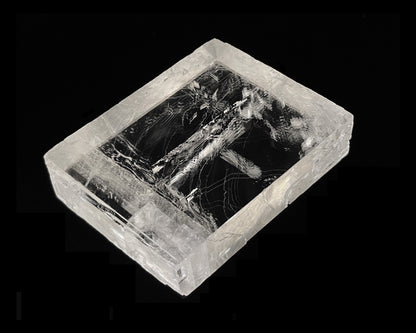 optischer Calcit mit Doppelbrechung auf schwarzem Hintergrund