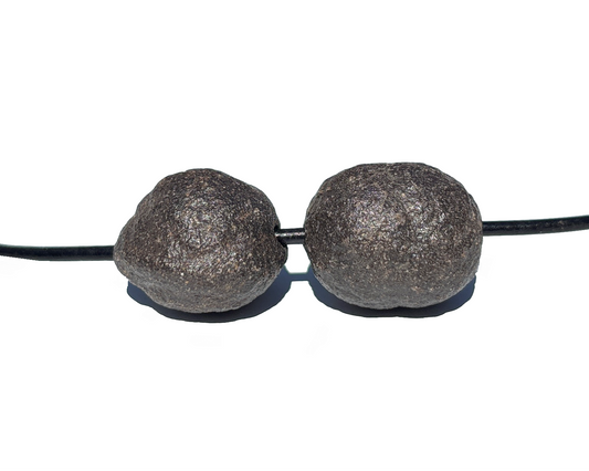 Moqui Marbles paarweise mit Band auf weißem Hintergrund