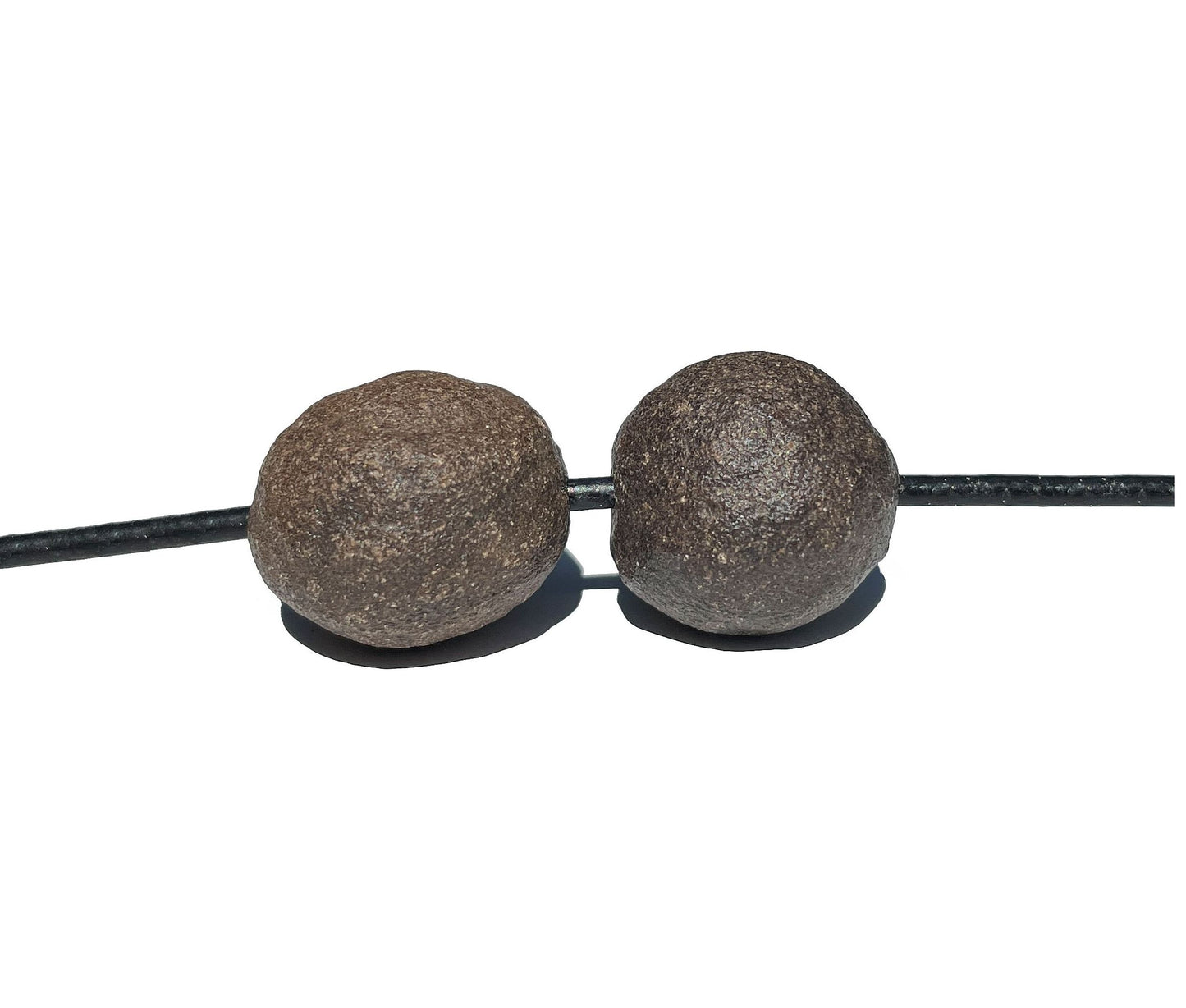 Moqui Marbles mit Band auf weißem Hintergrund