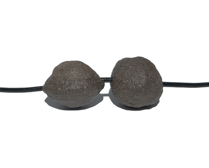 Moqui Marbles mit Band paarweise nebeneinander auf weißem Hintergrund