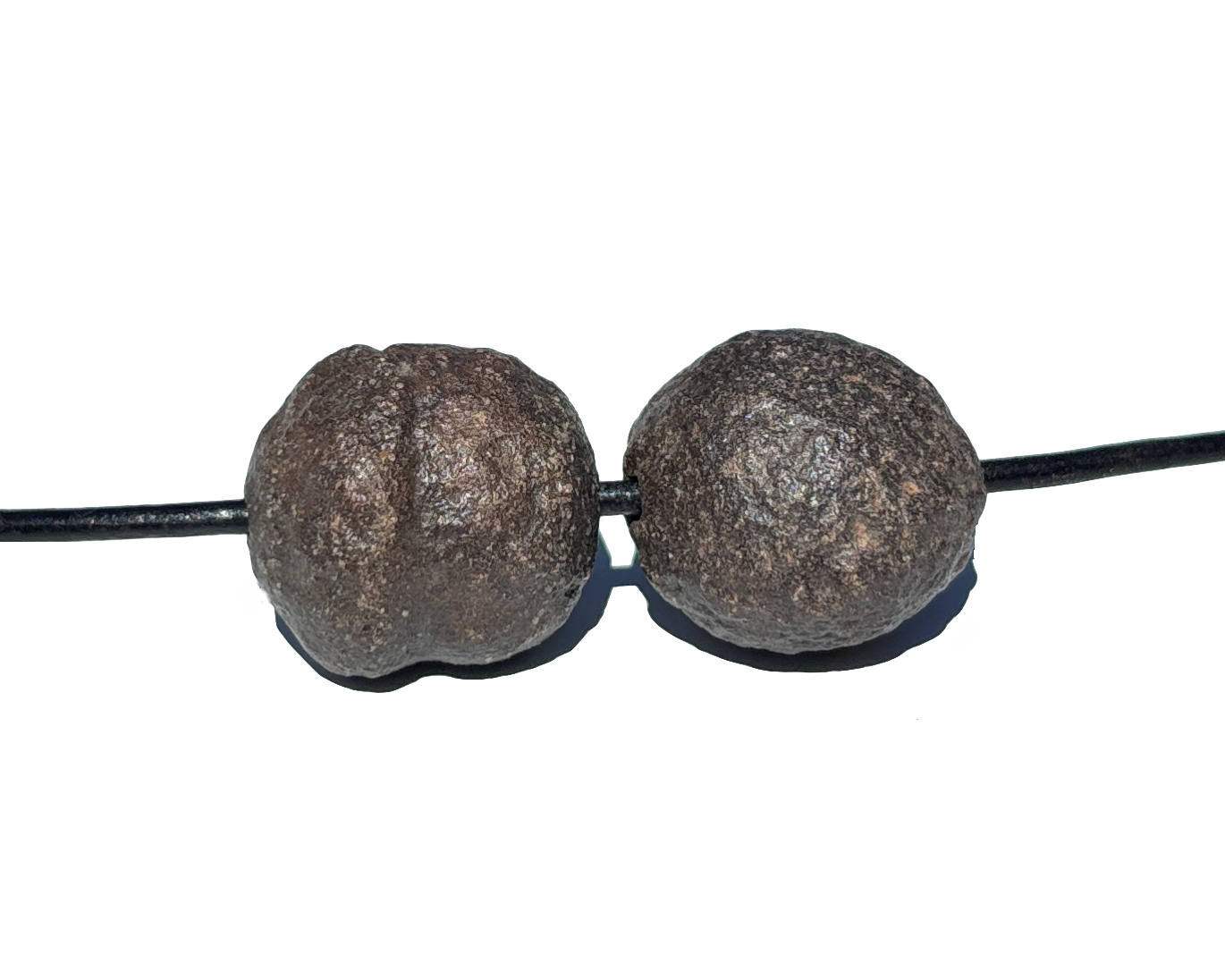 Moqui Marbles paarweise mit Band auf weißem Hintergrund