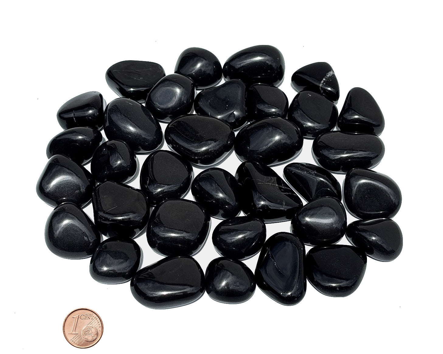 Ansicht von vorn: Onyx Trommelsteine Größenvergleich mit Pfennig auf weißem Hintergrund