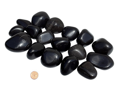 Ansicht von vorn: Onyx Trommelsteine Größenvergleich mit Pfennig auf weißem Hintergrund