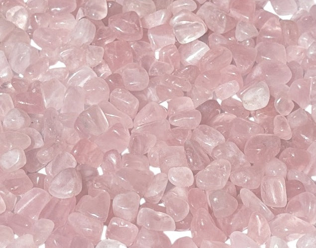 Ansammlung von Rosenquarz Trommelsteinen auf weißem Hintergrund