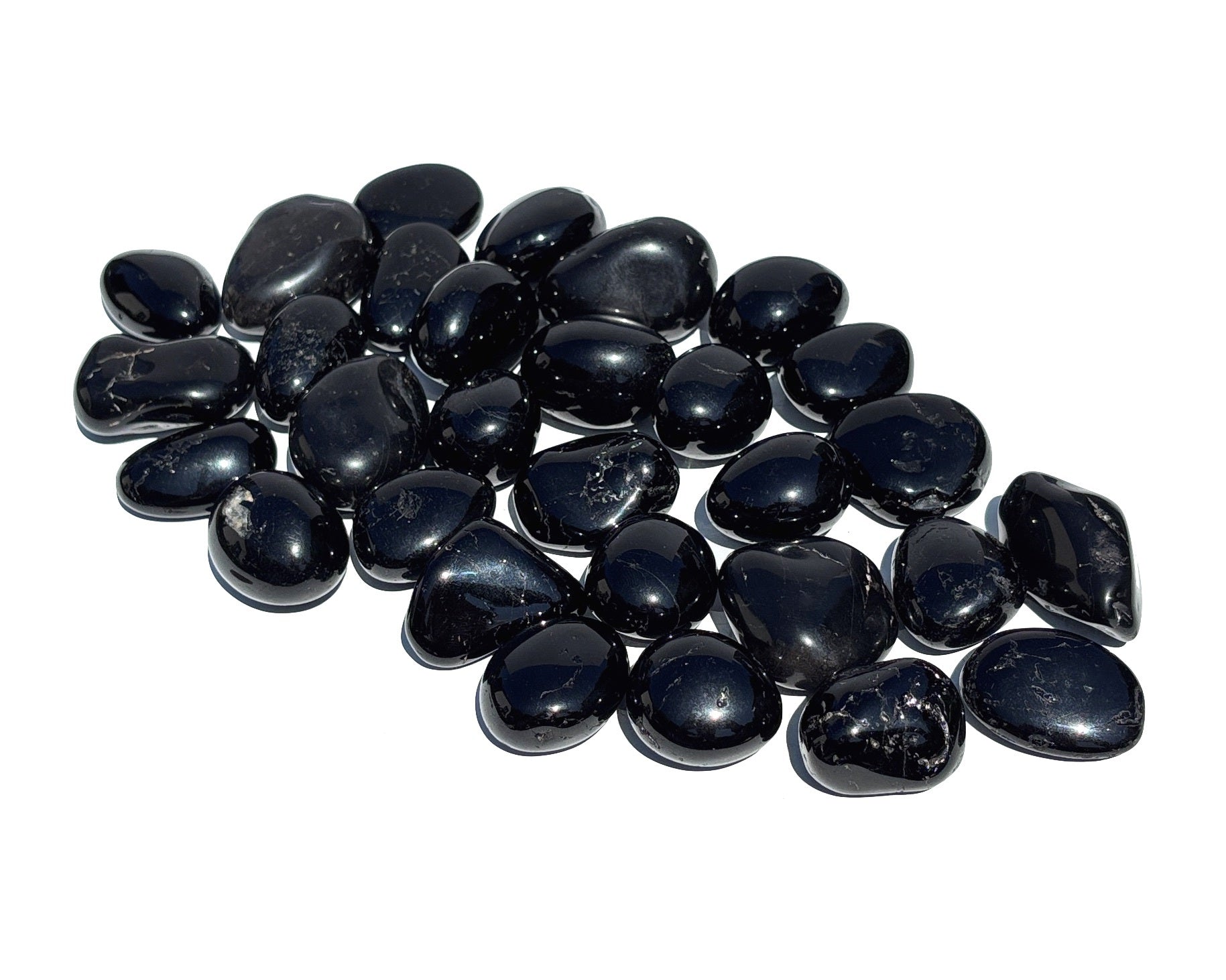 Vorderansicht: Ansammlung von Turmalin Trommelsteine auf weißem Hintergrund