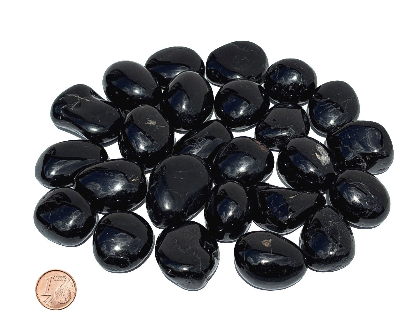 Vielzahl an Turmalin Trommelsteinen auf weißem Hintergrund Größenvergleich mit einem Pfennig
