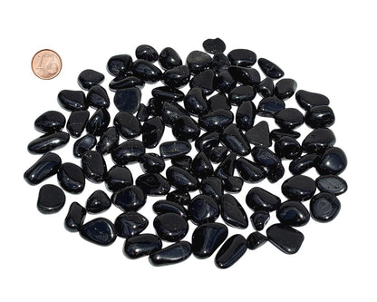 Vielzahl an Turmalin Trommelsteinen auf weißem Hintergrund Größenvergleich mit einem Pfennig