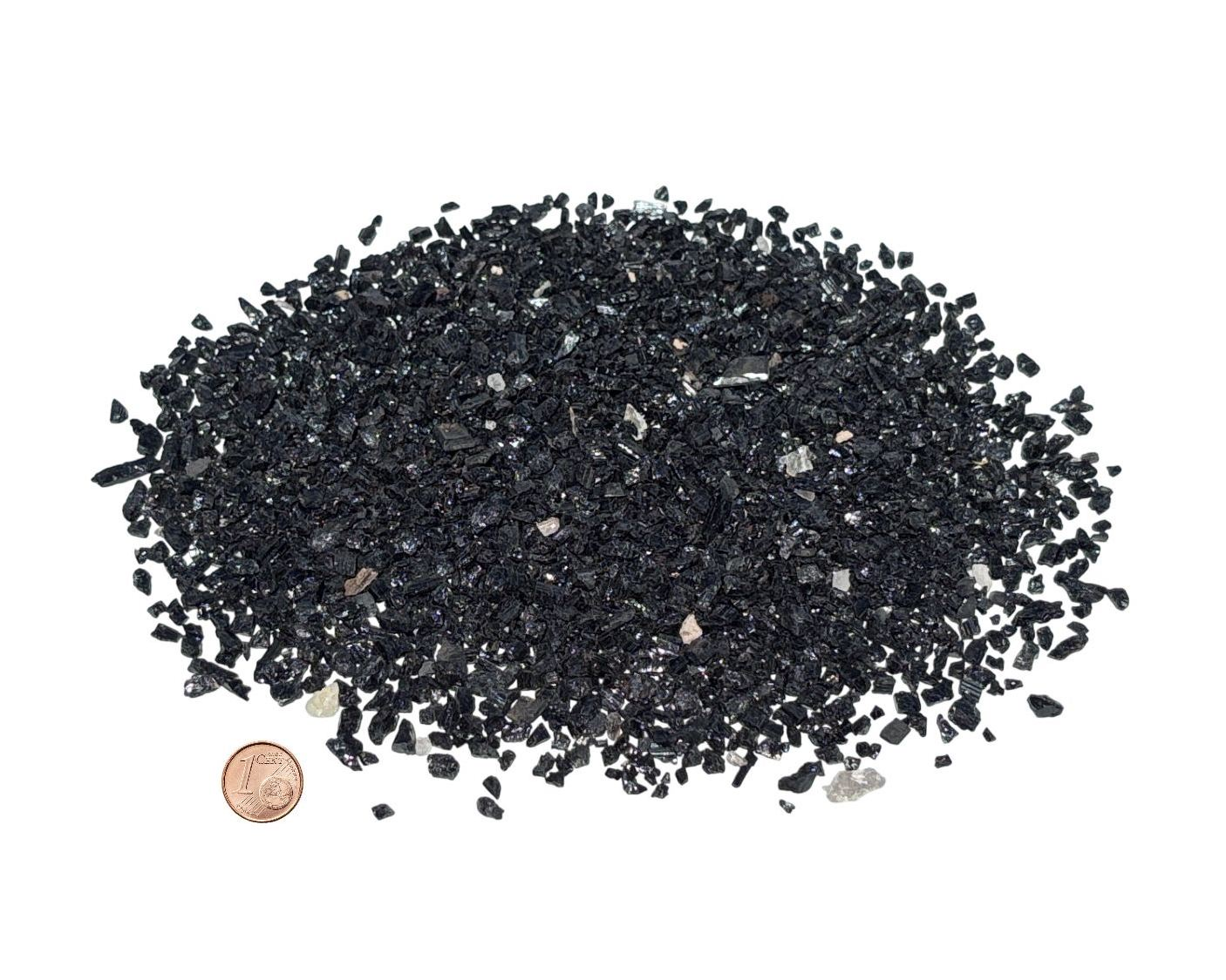 Vorderansicht: Vielzahl an Turmalin Kristallen auf weißem Hintergrund im Größenvergleich mit einem Pfennig